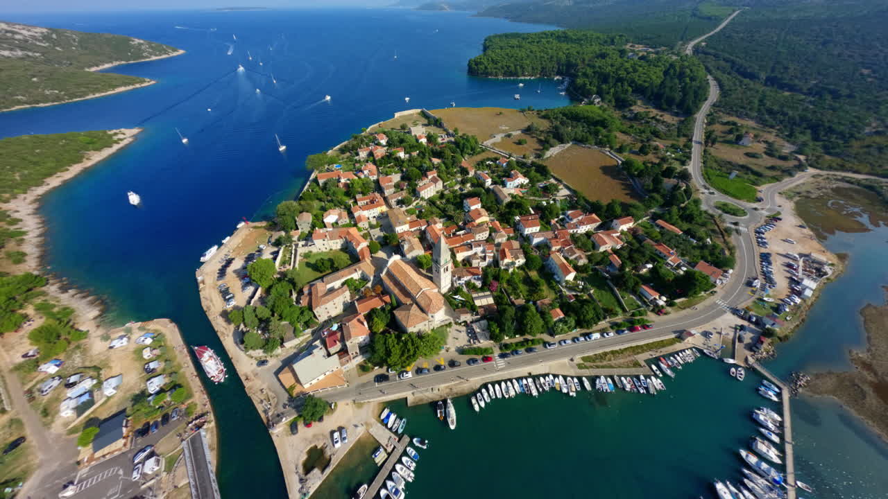 High angle aerial overview of Osor, cinematic FPV drone swoops down onto city