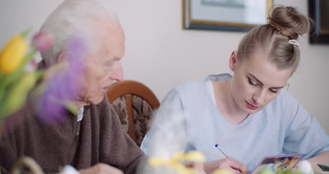 Grandfather-And-Granddaughter-Writing-Greeting-Cards-For-Easter-Holidays