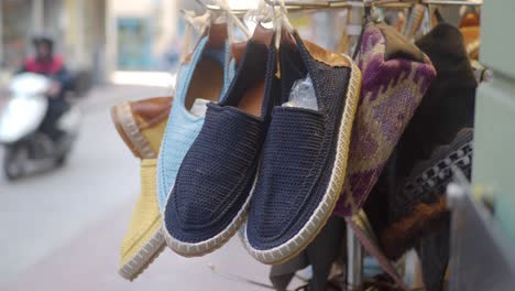 close-up of blue and brown espadrilles hanging in a store