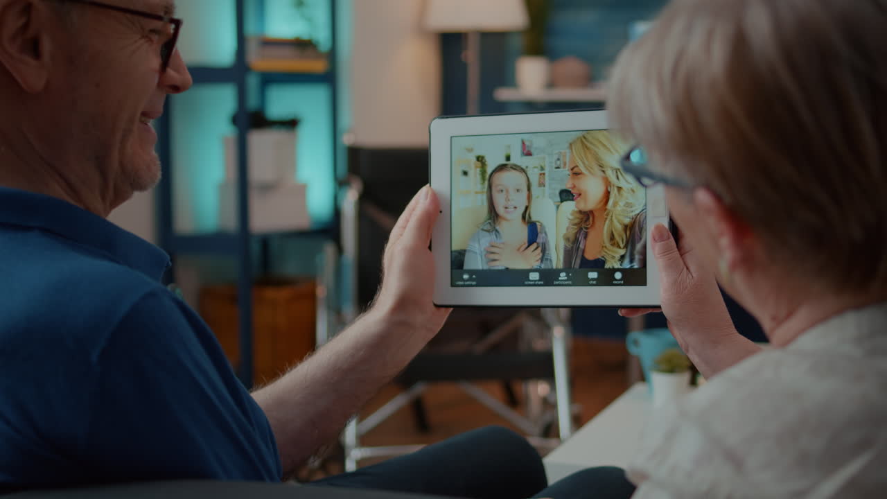 Senior couple having a video call with family on a tablet
