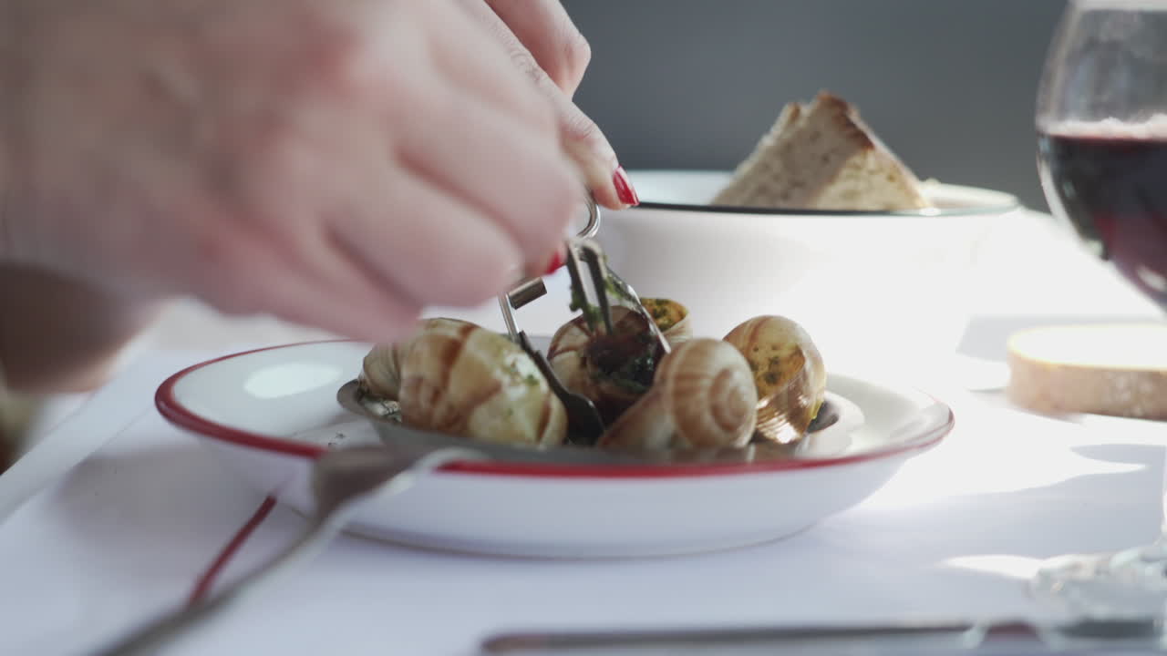 mujeres comiendo caracoles franceses con un tenedor tradicional