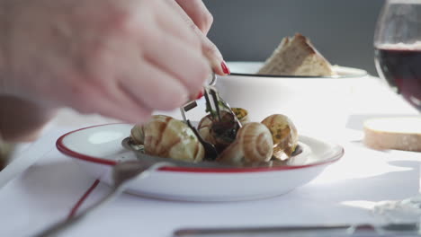 women eating french escargots with traditional fork