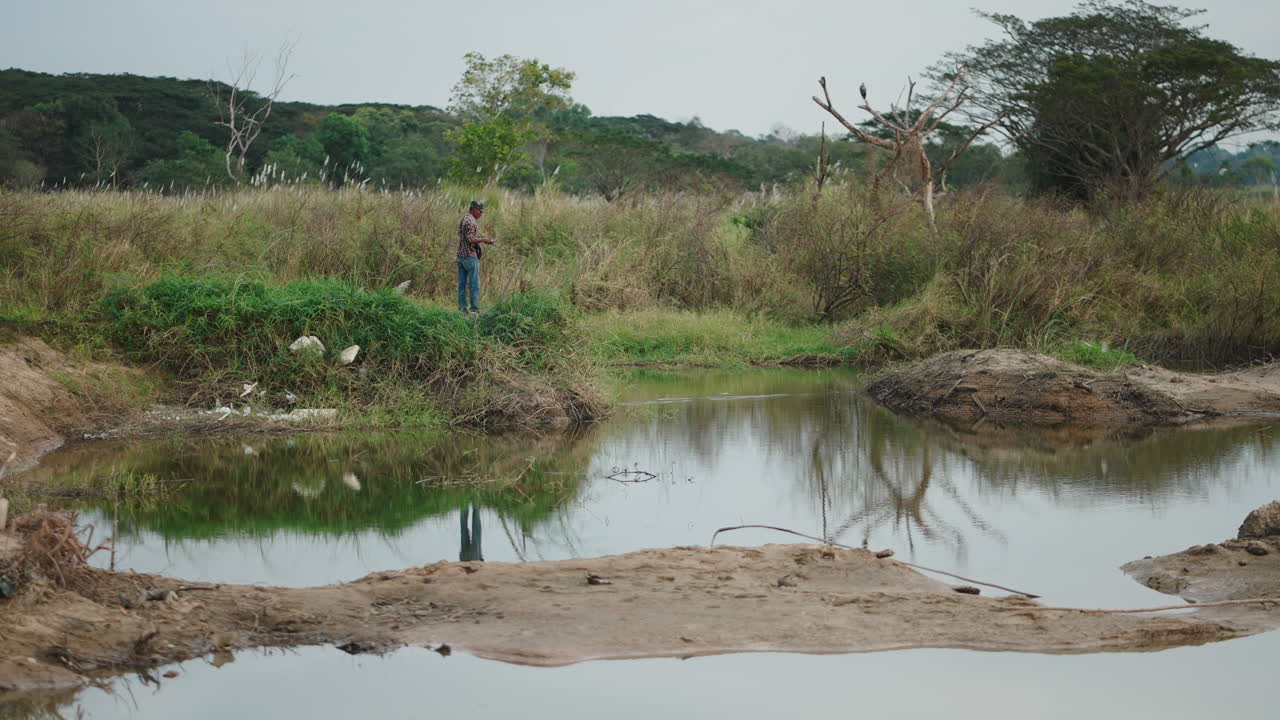 Homem pescando em um lago tranquilo em uma paisagem rural