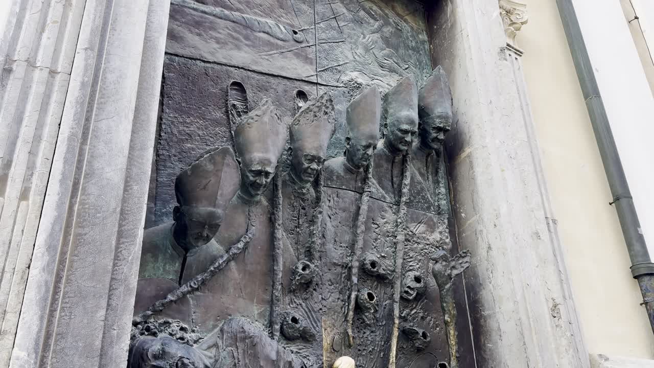 Iconic tourist attraction, bronze 'Ljubljana Door' on the side entrance of St Nicholas Cathedral, depicting 5 bishops - Ljubljana, Slovenia