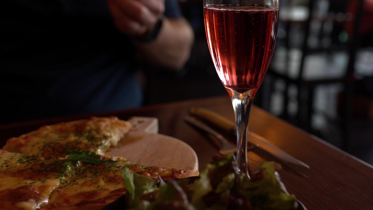 Primo piano di un bicchiere di spumante e pizza su un tavolo di ristorante a Kyoto