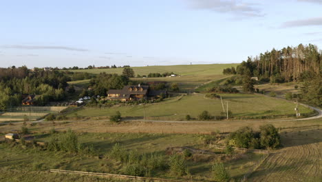 toma aérea de una granja rural en el campo con hermosos árboles forestales, paisaje en otoño al atardecer