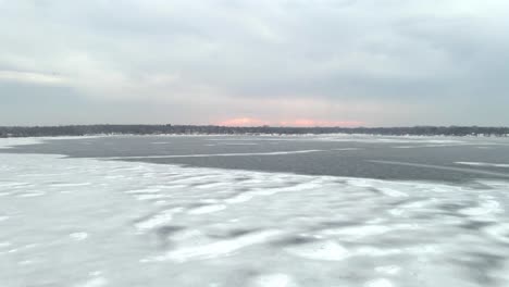 Aerial-view-of-a-lake-frozen-ice-layer-and-intersting-patterns-on-nature