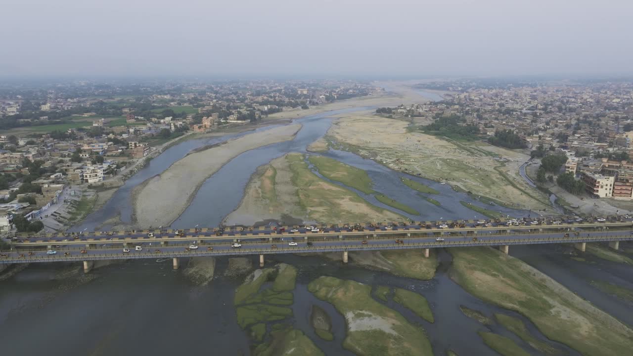 Jalalabad, Nangarhar, Afghanistan. Drone Aerial View of Bridge Traffic Above Kabul River and Buildings on Riverbanks