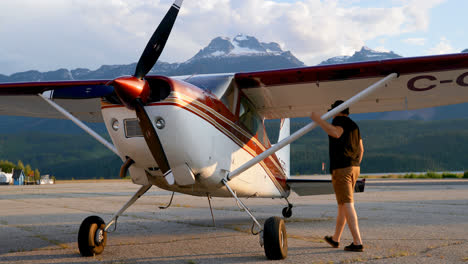 Pilot-examining-aircraft-near-hangar-4k-