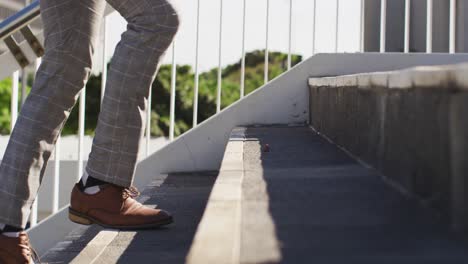 Beine-Eines-Afroamerikanischen-Mannes,-Der-Die-Treppe-Hinauf-In-Die-Stadt-Geht