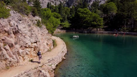 Blonde-girl-walking-around-Jablanac-Inlet,-scenic-natural-coastal-landscape,-Croatia