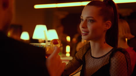 Man-and-smiling-woman-clinking-glasses-in-bar.-Girl-drinking-cocktail-in-club