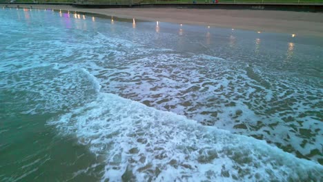 Aerial-footage-of-the-tide-as-it-reaches-Portrush-West-Strand-beach,-Northern-Ireland