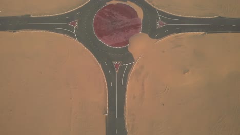 aerial view from drone of abandoned desert roads covered with sand dunes in dubai, united arab emirates