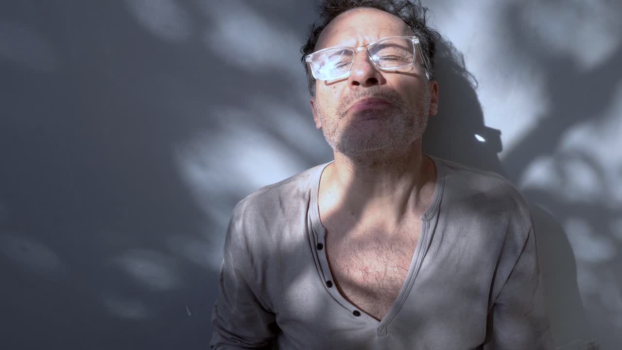 평범한 옷을 입은 성인 남성이 손에 고 있는 약을 연구하고, 자연빛에 담긴 반성과 자아보살의 순간.