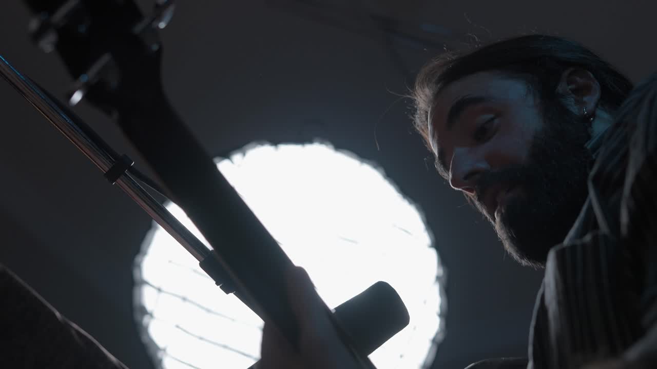 Man Playing Bass Guitar in Recording Studio