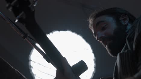 man playing bass guitar in recording studio