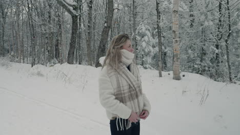 Mujer-Mirando-Alrededor-De-árboles-Desnudos-Cubiertos-De-Nieve-En-Un-Camino-Rural-De-Invierno-En-Orford,-Quebec,-Canadá---Tiro-Medio