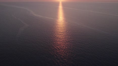 Aerial-view-of-boats-on-calm-sea-with-people-during-sunset,-Cefalu,-Sicily,-Italy