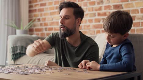 handheld video of boy solving jigsaw puzzle with father