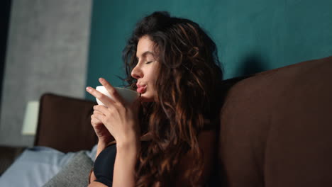 young lady drinking coffee in bedroom