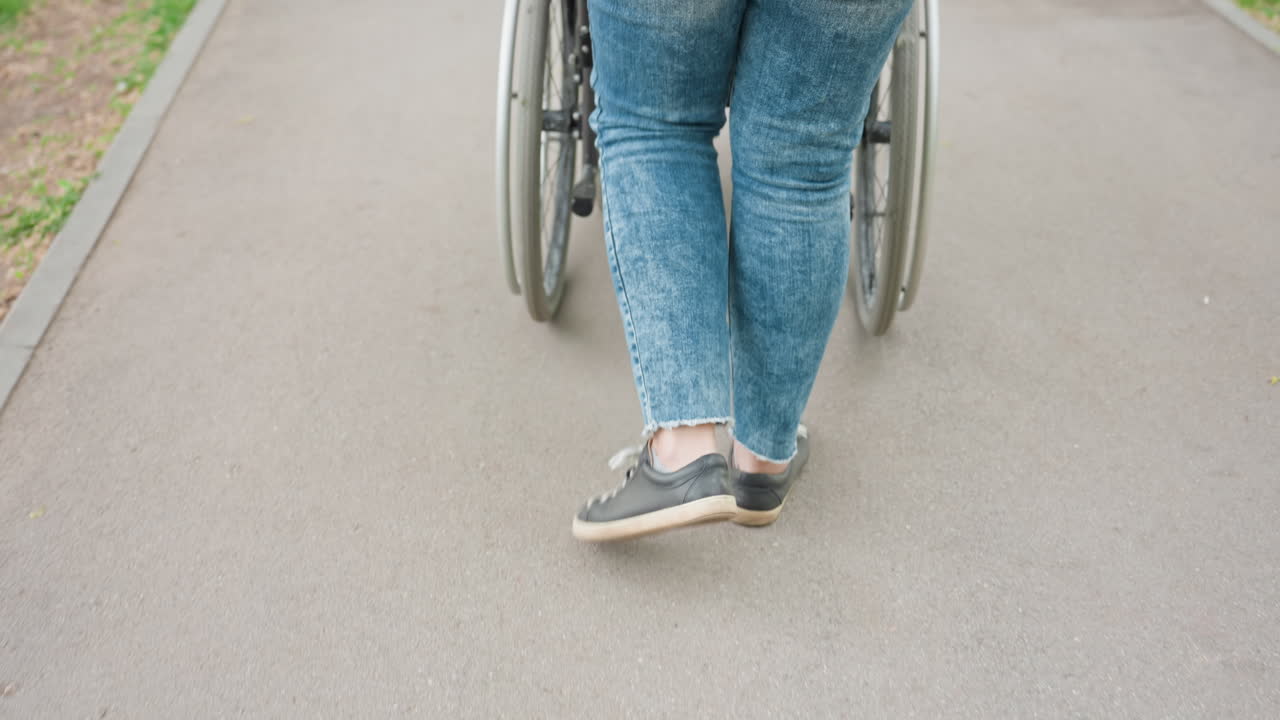 Supportive Walk Behind Wheelchair, Walking Aid Providing Steady Support Outdoors For Mobility, Caregiver Assisting With Wheelchair On Outdoor Route Through Supportive Stepping And Guidance