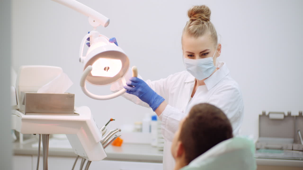il dentista femminile tratta il paziente alla clinica odontoiatrica 1