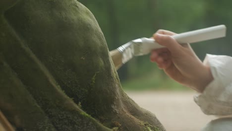 hand holding brush to remove dust from old stone sculpture