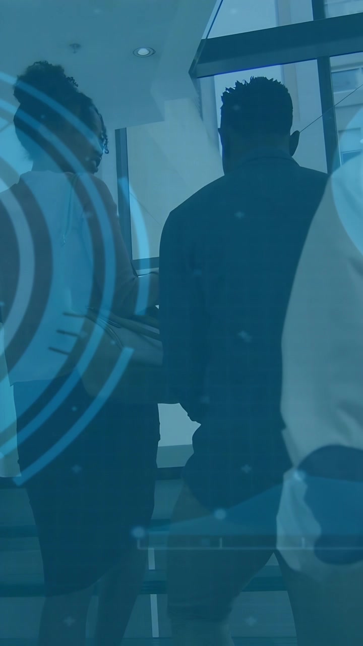 Vídeo vertical: Um par subindo escadas, um terceiro seguindo até o patamar, tecnologia sobreposta rastreando à esquerda.
