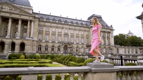 beautiful woman wearing colourful clothes playfully walking, old building behind