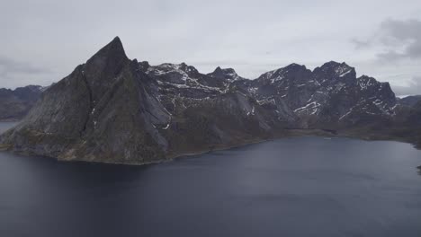 vista aérea de picos empinados con nieve, en nublado, lofoten, noruega - pan, tiro de drone