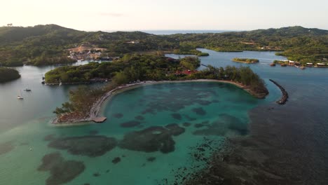 Aerial-top-view-of-tropical-island,-sailboats-and-colorful-reef-,-FAntasy-island-in-Roatan-island,-Atlantida,-Honduras