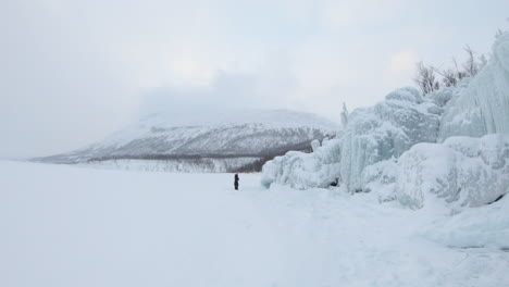 girl walking of a big iceberg on a frozen lake in björkliden, sweden