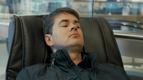 hombre descansando en la silla de masaje
