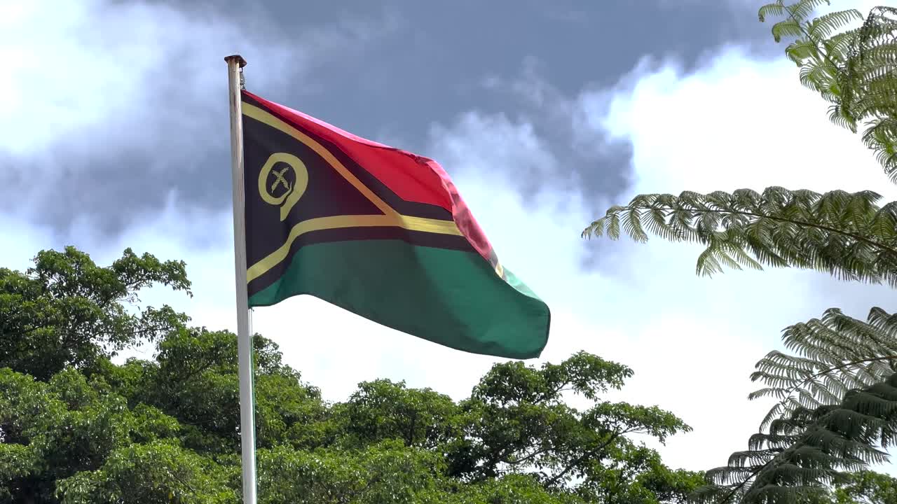 Bandiera di Vanuatu sventola sull'asta, sfondo giungla, Isole del Pacifico. Simbolo nazionale