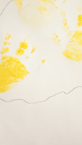 child making hand prints on paper. early childhood education. little painter. vertical video