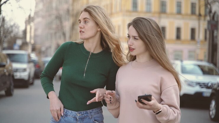 Due amici turisti in città cercano un indirizzo sul cellulare.