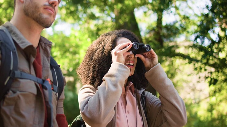 Escursionisti che usano il binocolo in una foresta