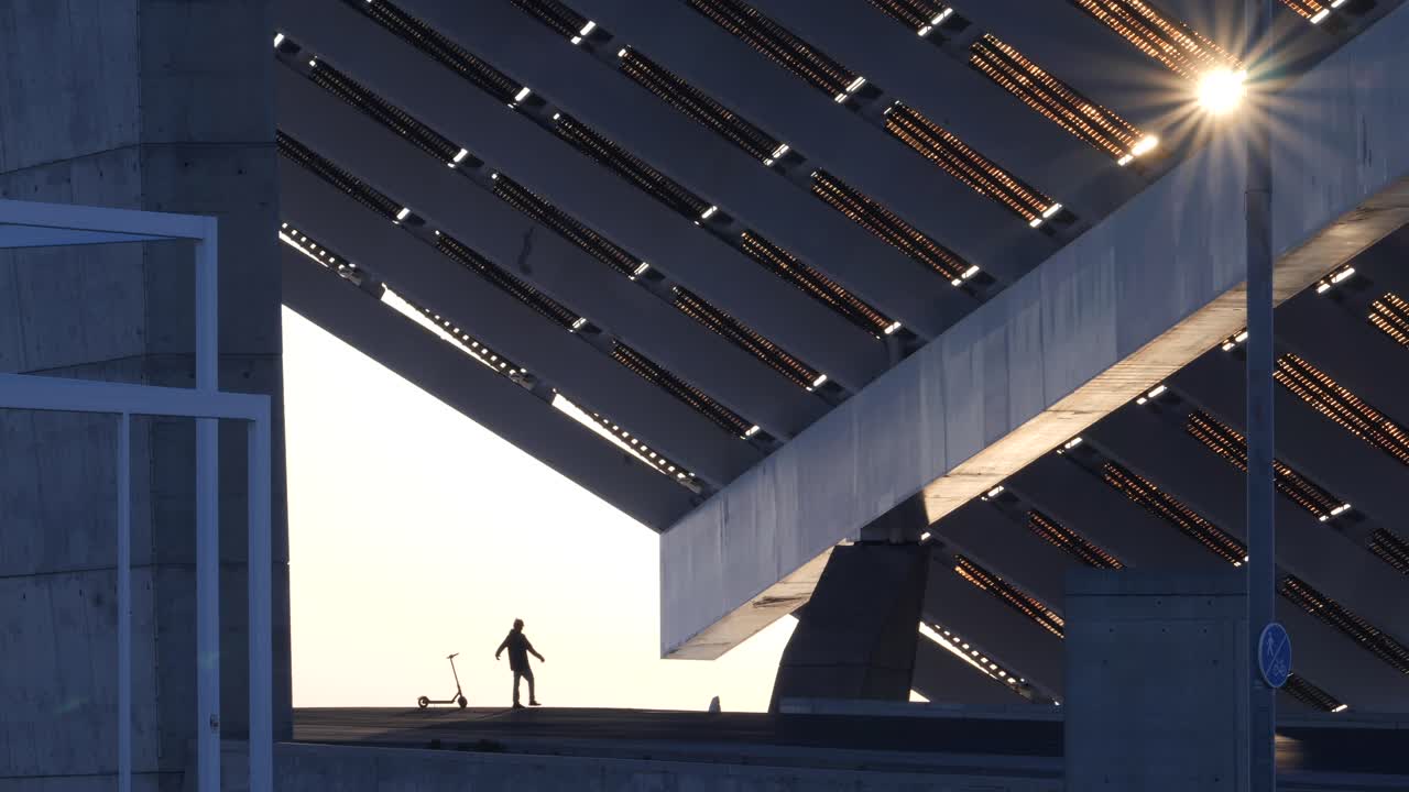 hombre silueta levanta los brazos en celebración y luego se va en scooter eléctrico