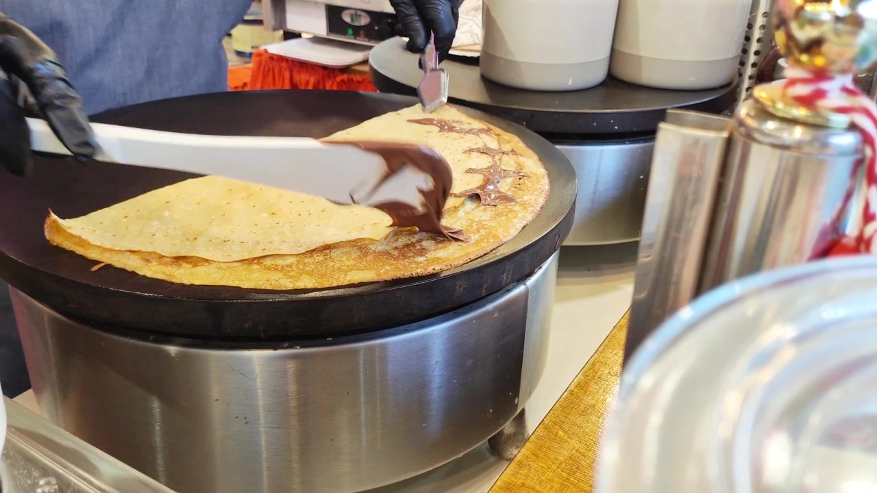 Venditore di street food che prepara una crepe fresca