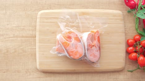 frozen salmon fillets on wooden board