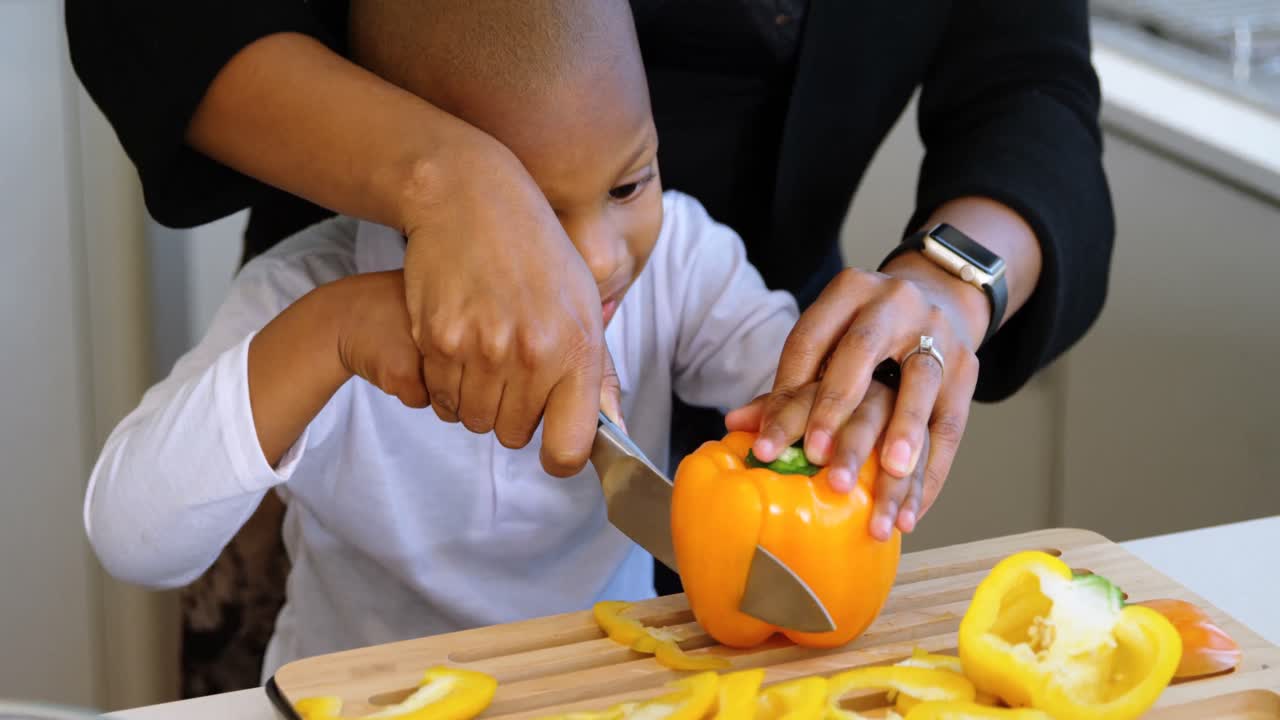 Mother and son chopping vegetables in kitchen at home 4k