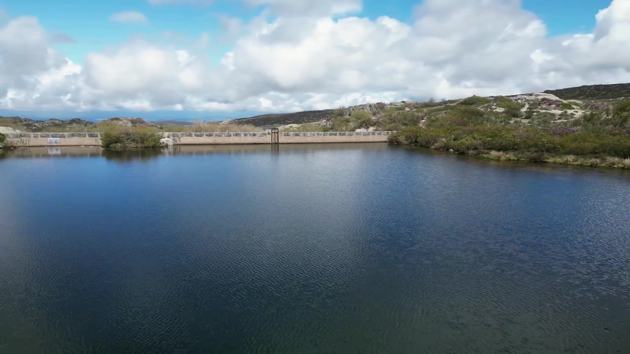 Riprese aeree con drone della Serra da Estrela, Portogallo: cime montuose rocciose, bacini idrici e vasto paesaggio naturale sotto una luce chiara. Ideale per progetti di viaggio e natura