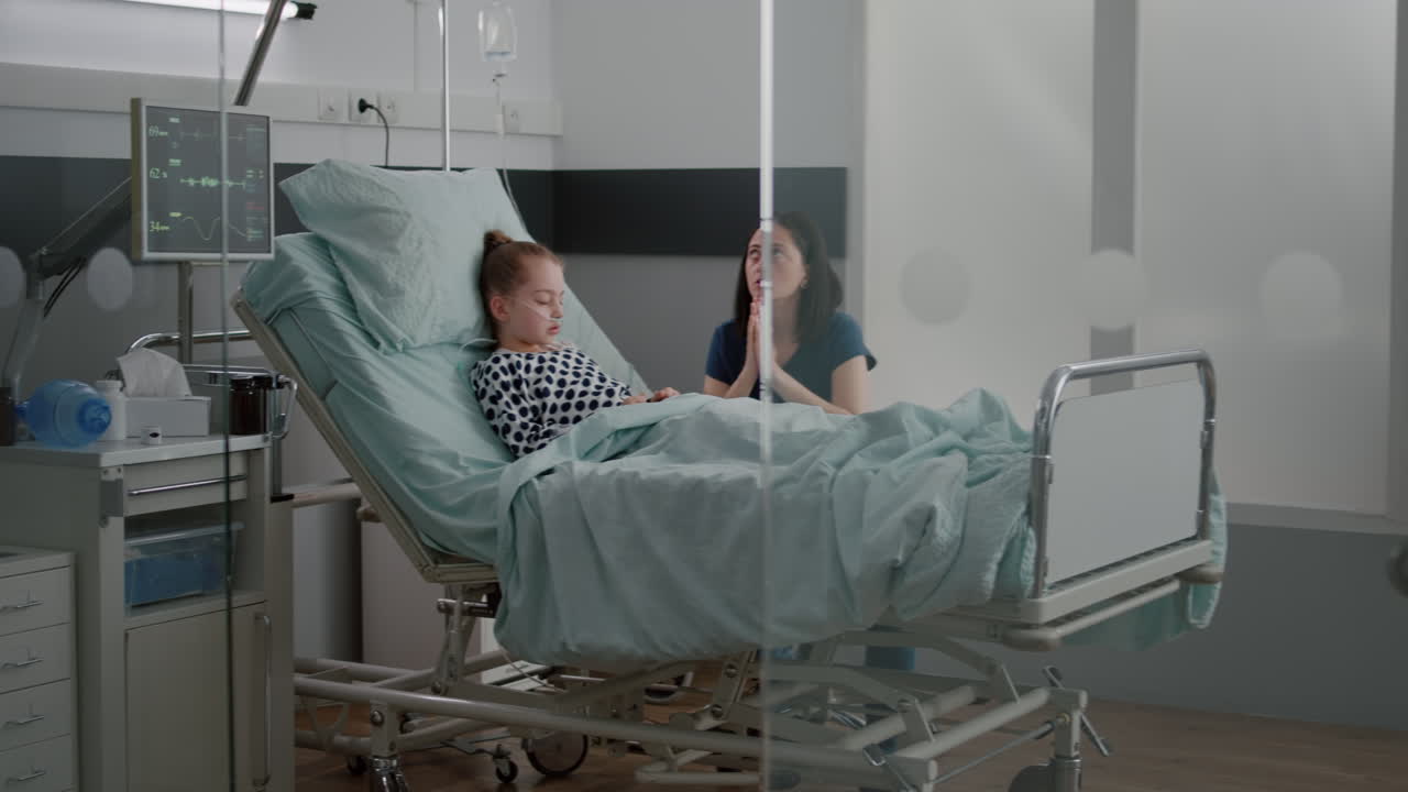 Sick daughter sleeping after recovery surgery while worried mother prating for healthcare treatment