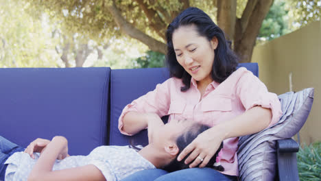 mother and daughter relaxing on couch outside home 4k