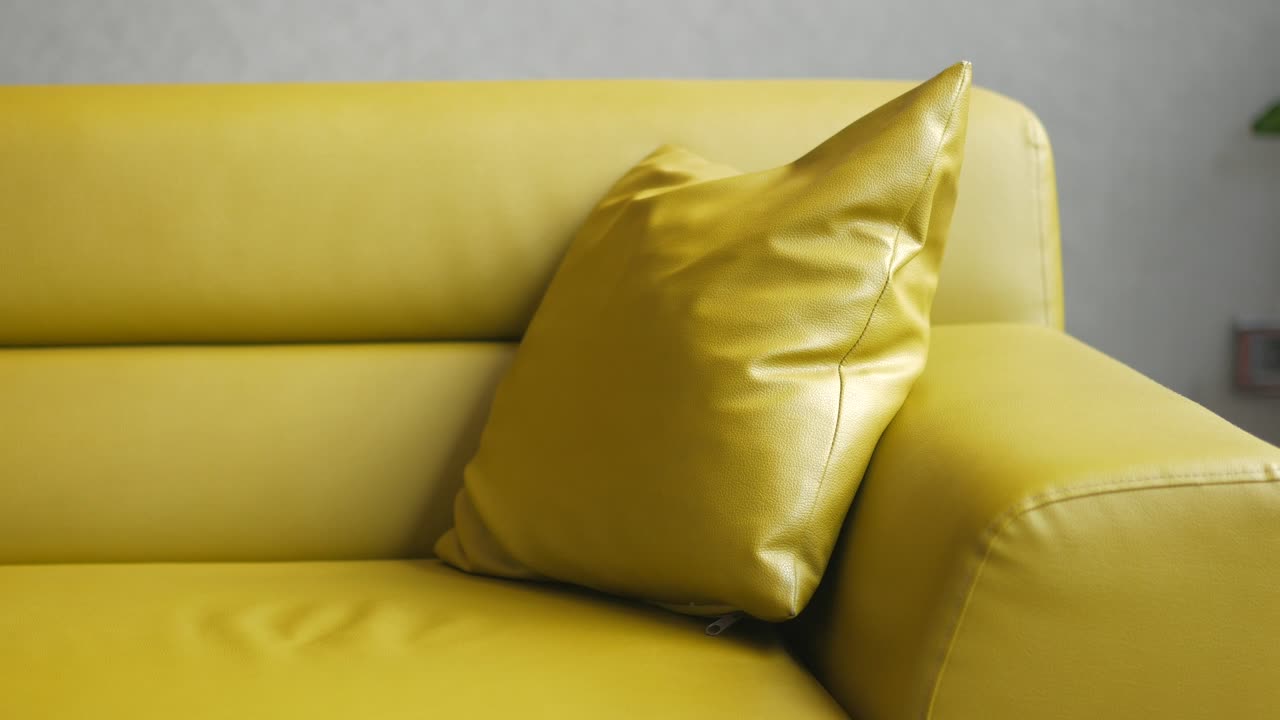 sofá de cuero amarillo con almohada