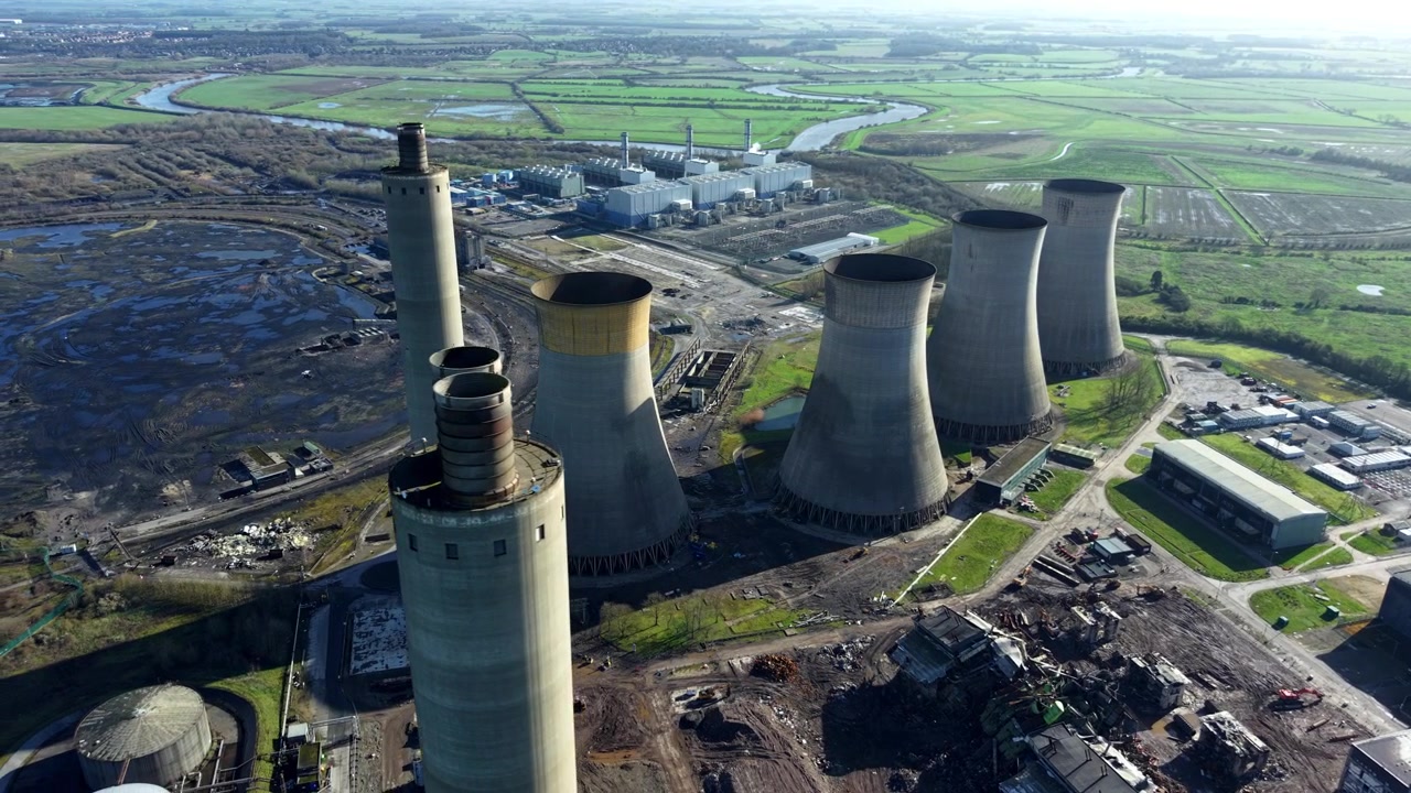 Lenta orbita aerea attorno al sito di generazione di energia di West Burton che mostra torri di raffreddamento e turbine CCGT