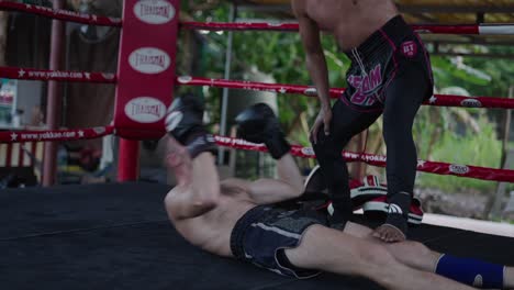 two men training martial arts with pads in a boxing ring