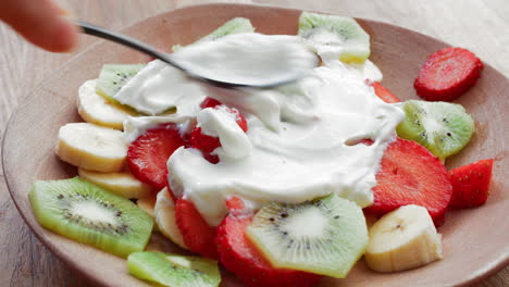 ensalada de frutas con yogur griego en un plato