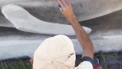 Overhead-video-of-caucasian-male-artist-painting-whale-mural-on-wall